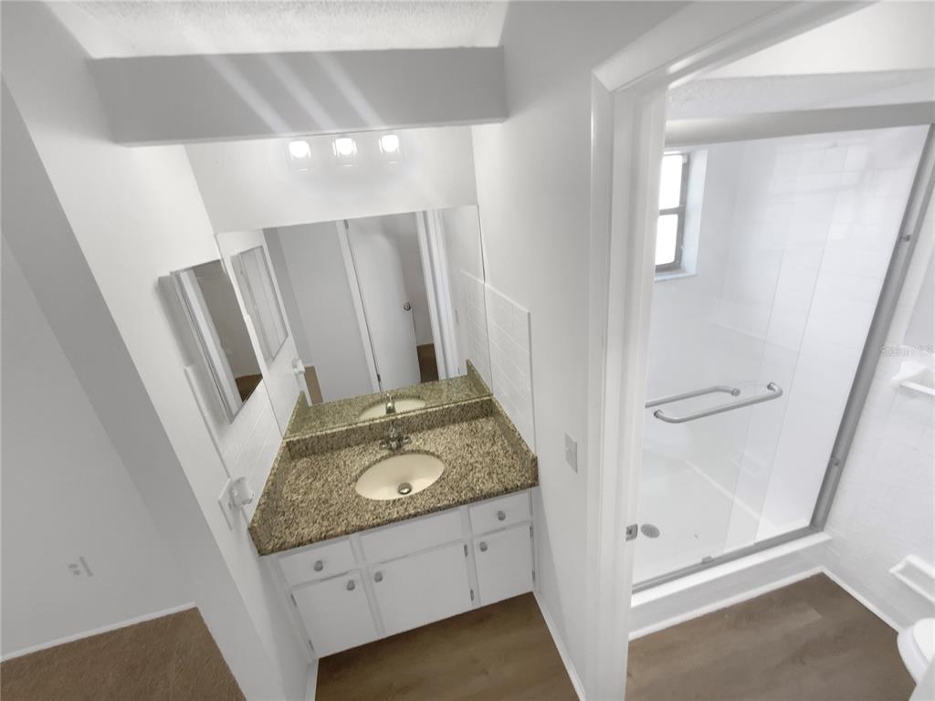 7846 Cayuga Drive New Port Richey, FL 34653 - Photo 22 of 32 a bathroom with a granite countertop sink and a mirror