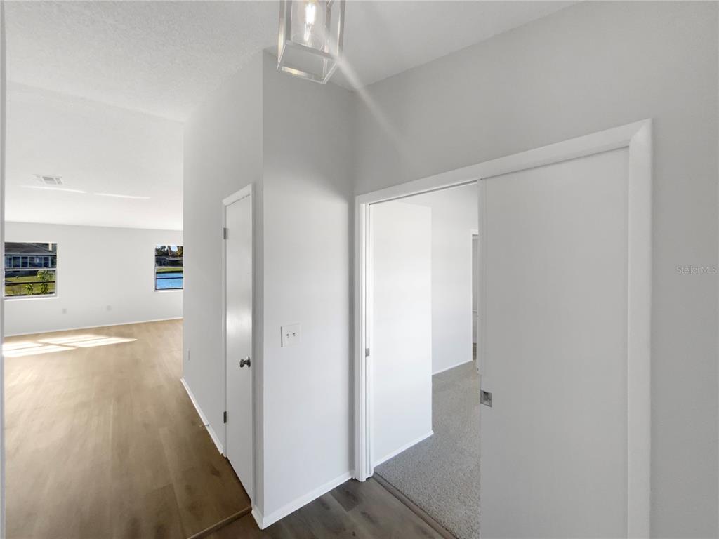 7846 Cayuga Drive New Port Richey, FL 34653 - Photo 28 of 32 a view of a hallway with wooden floor and a bathroom