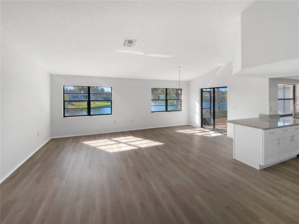7846 Cayuga Drive New Port Richey, FL 34653 - Photo 3 of 32 an empty room with wooden floor and windows