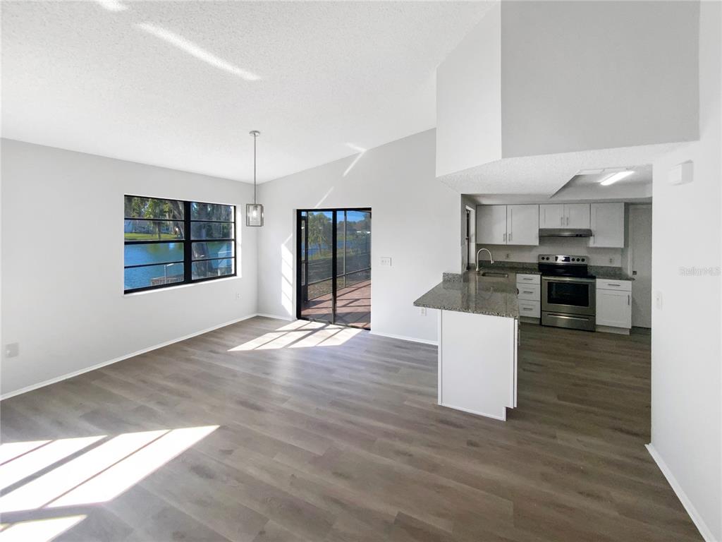 7846 Cayuga Drive New Port Richey, FL 34653 - Photo 10 of 32 a view of kitchen with stainless steel appliances kitchen island wooden floor and living room view