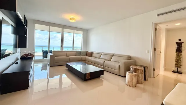 a living room with furniture and a floor to ceiling window