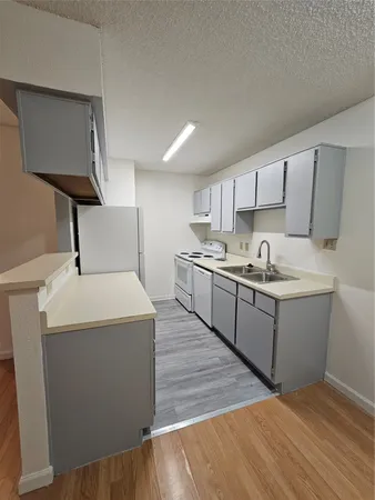 a kitchen with a sink a stove and cabinets
