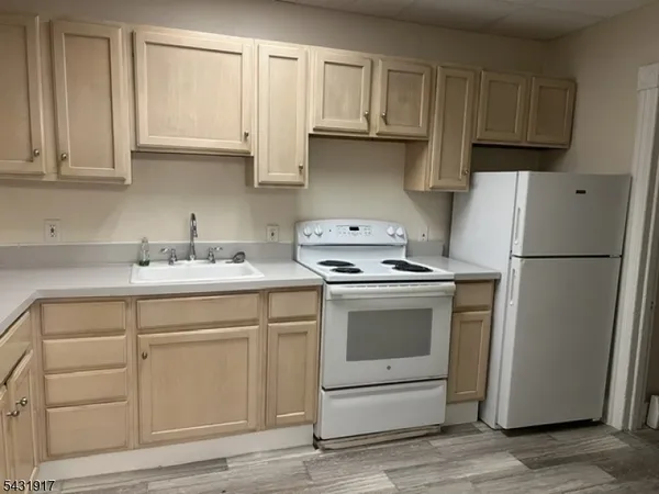a kitchen with white cabinets and white appliances