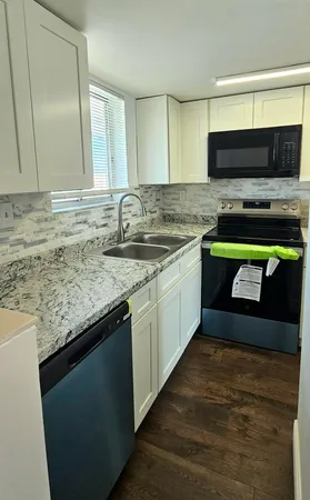 a kitchen with stainless steel appliances granite countertop a sink stove and microwave