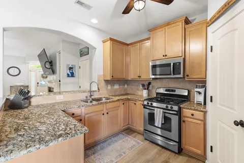 a kitchen with kitchen island a counter top space a sink and stainless steel appliances