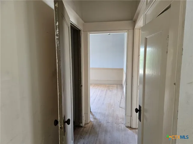 a view of empty room with window and wooden floor