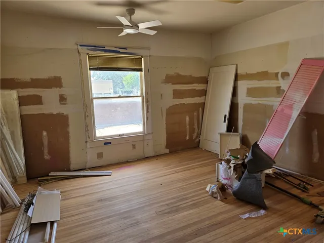 a view of a door and chair in a room with wooden floor
