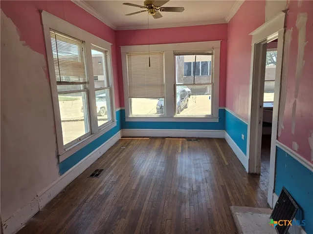 a room with wooden floor and windows
