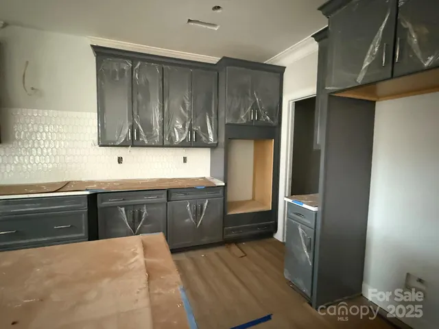 a kitchen with stainless steel appliances kitchen island granite countertop a refrigerator and cabinets