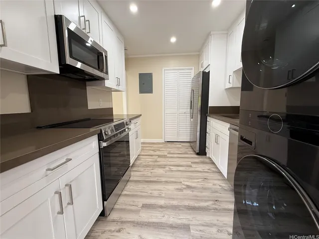 a kitchen with stainless steel appliances a stove microwave and sink