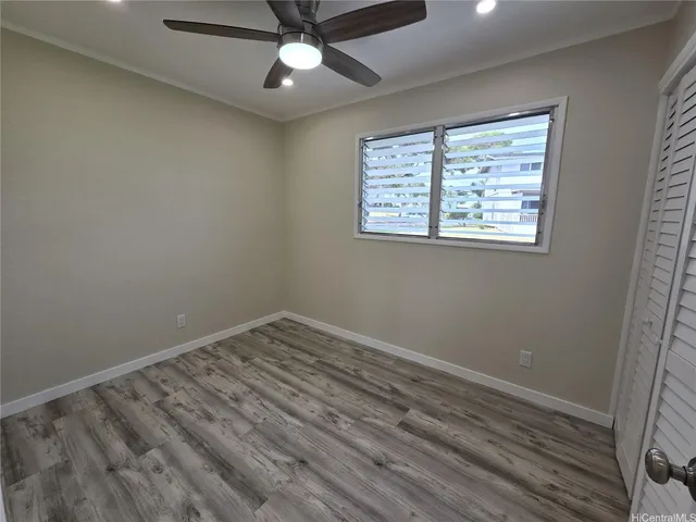 an empty room with a window and a fan