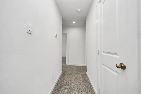 an empty room with a window and ceiling fan