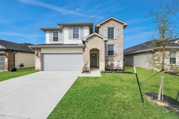 a front view of a house with a yard and garage