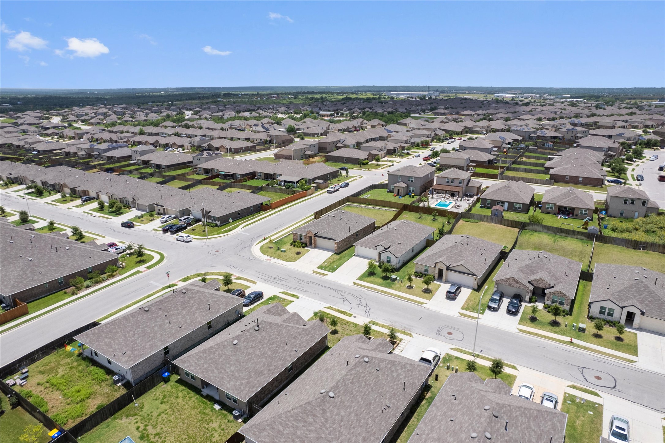 19525 Abigail Fillmore Road Manor, TX 78653 - Photo 3 of 38 An aerial perspective reveals a sprawling neighborhood with uniform homes and ample community spaces.