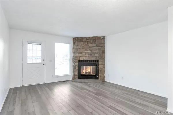 an empty room with windows and a fireplace