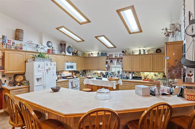 a dining room with stainless steel appliances granite countertop a dining table and chairs