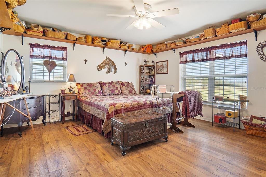 19355 Southwest 25th Place Dunnellon, FL 34431 - Photo 27 of 38 a spacious bedroom with a bed a table and three large mirror with wooden floor