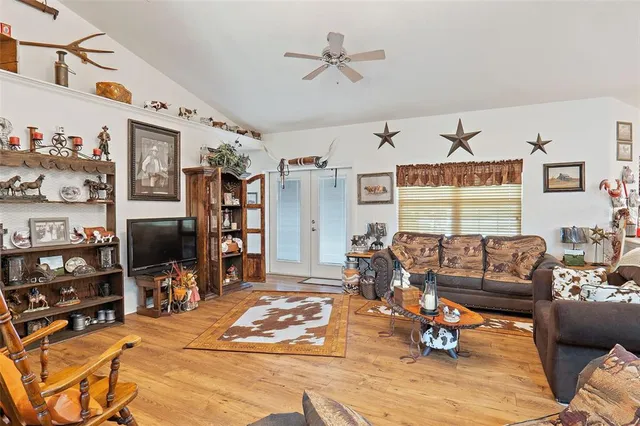 a living room with furniture a wooden floor and a flat screen tv