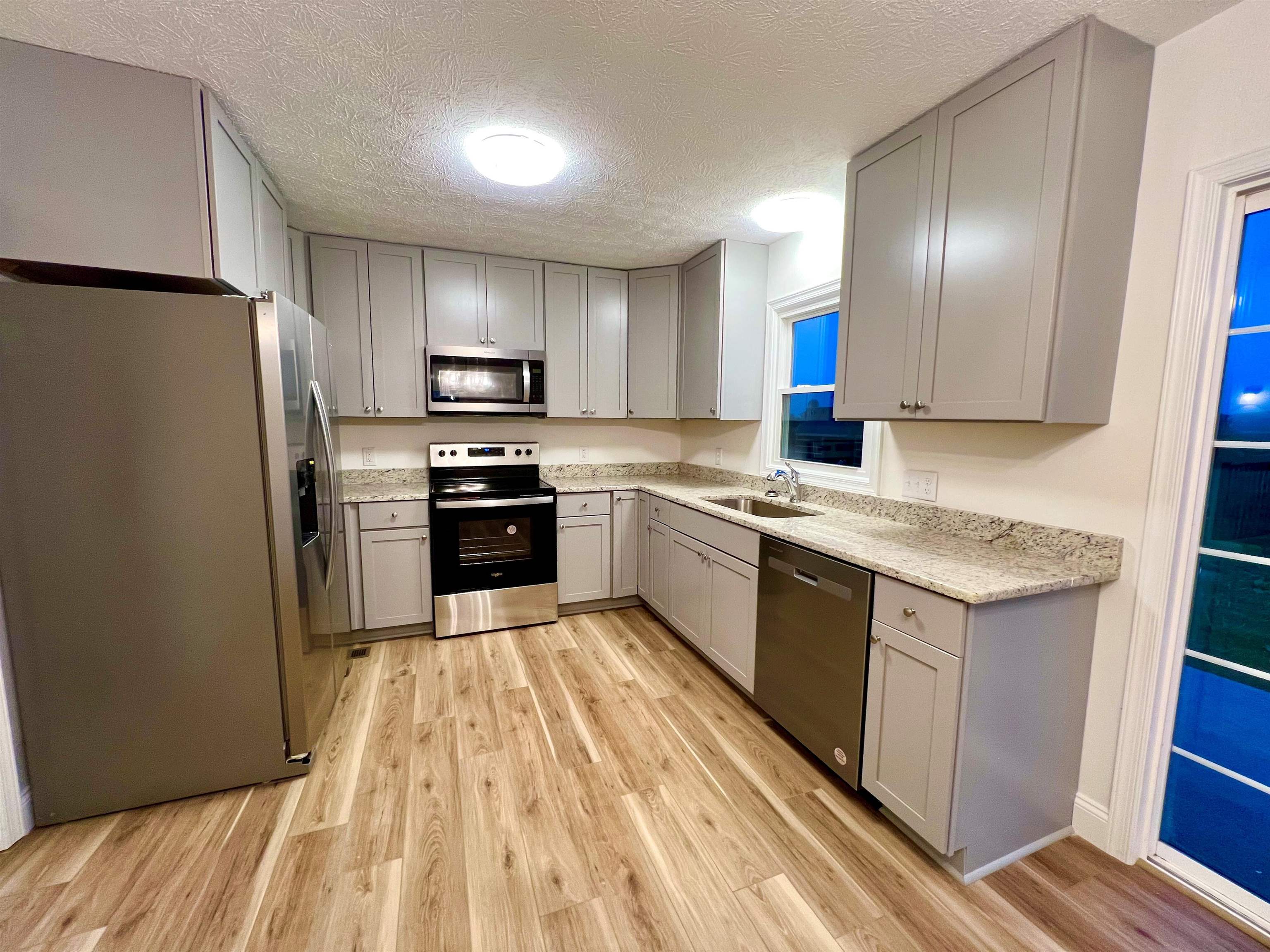 10293 Cook Town Road Bridgewater, VA 22812 - Photo 5 of 22 a kitchen with granite countertop stainless steel appliances cabinets a sink and a refrigerator