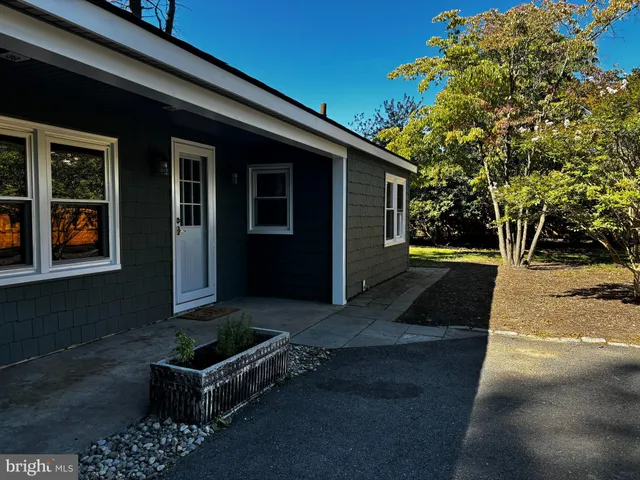 a view of house with backyard outdoor seating and trees