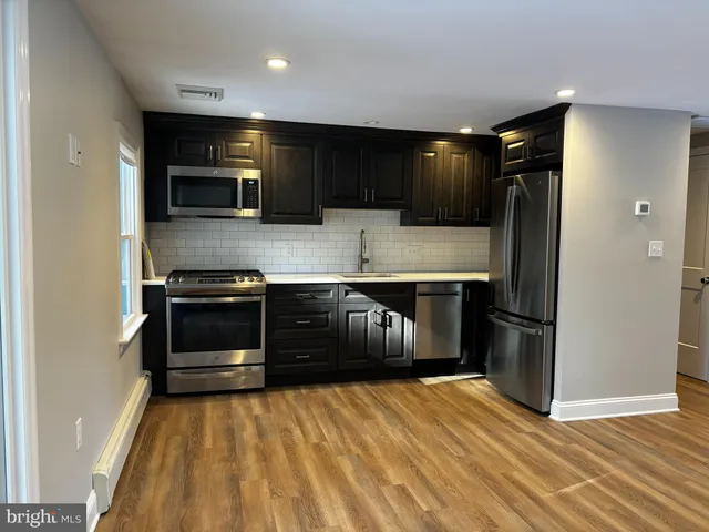 a kitchen with stainless steel appliances a refrigerator and a stove top oven