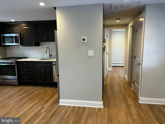 a view of a kitchen with wooden floor and cabinets