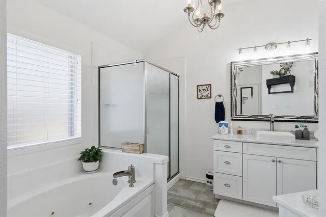 a bathroom with a bathtub a double vanity sink and mirror