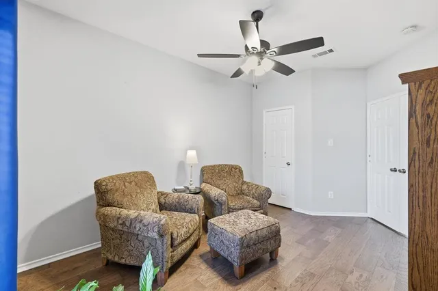 a living room with furniture and a ceiling fan