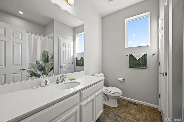 a bathroom with a sink a toilet and a large mirror