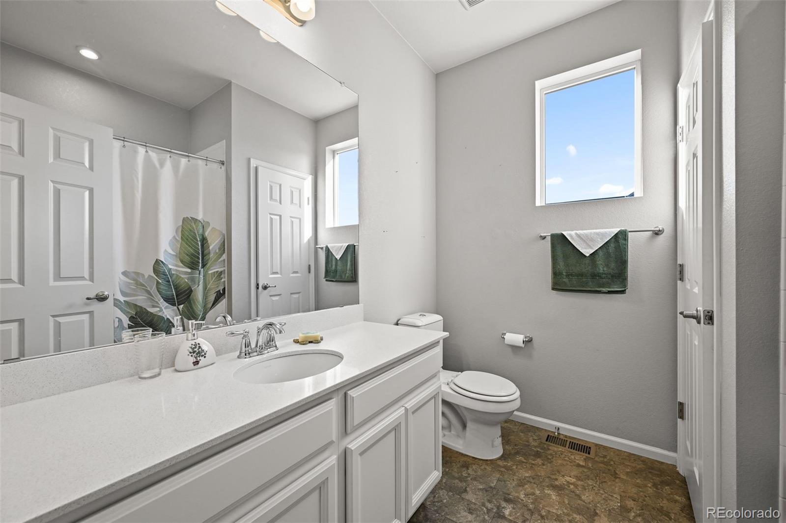 5230 Periwinkle Way Brighton, CO 80640 - Photo 25 of 44 a bathroom with a sink a toilet and a large mirror
