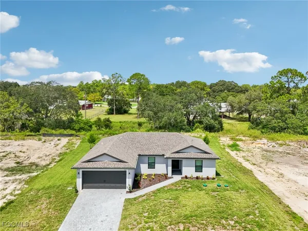 a aerial view of a house with a yard and large trees