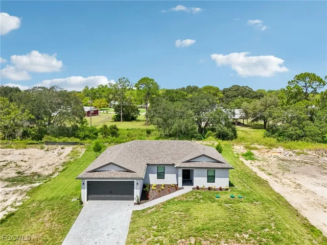 a aerial view of a house with a yard and large trees