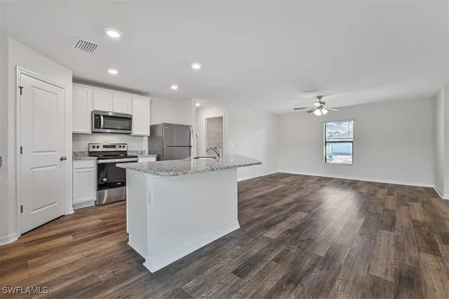 a kitchen with granite countertop a stove top oven and cabinets