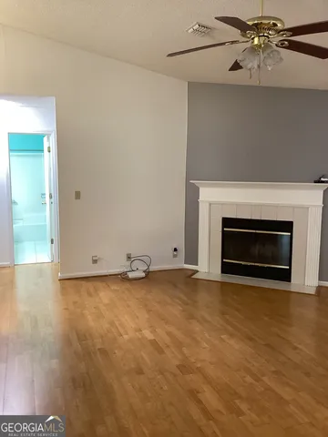 a view of empty room with wooden floor and fireplace