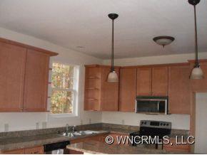 693 Rambling Creek Road Tryon, NC 28782 - Photo 3 of 12 a kitchen with a refrigerator a stove and a microwave