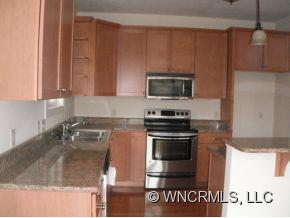 693 Rambling Creek Road Tryon, NC 28782 - Photo 4 of 12 a kitchen with granite countertop a stove and a sink