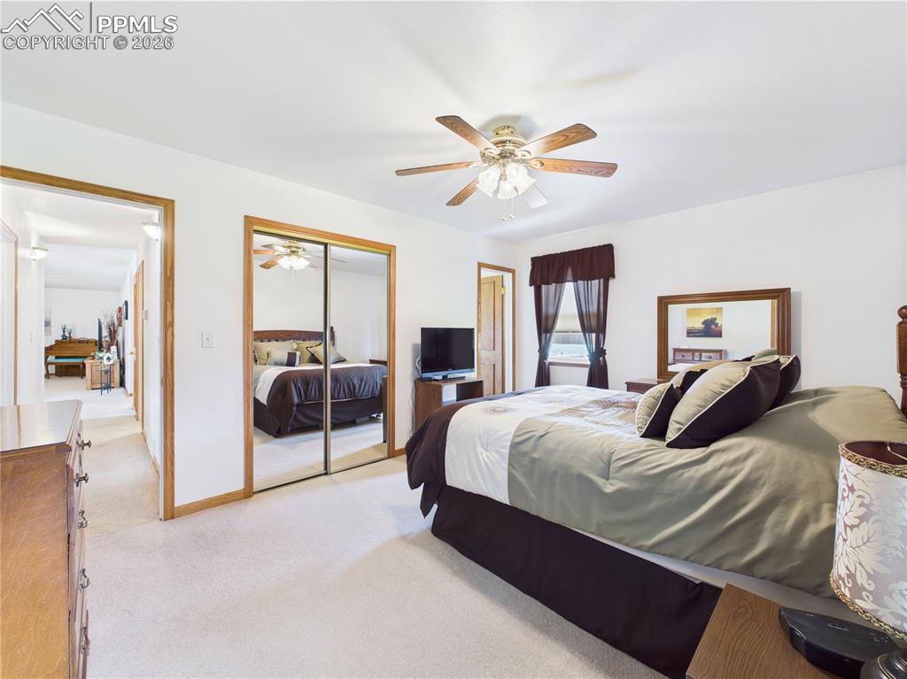 32006 Ford Road Pueblo, CO 81006 - Photo 31 of 50 a bedroom with a large bed and a chandelier