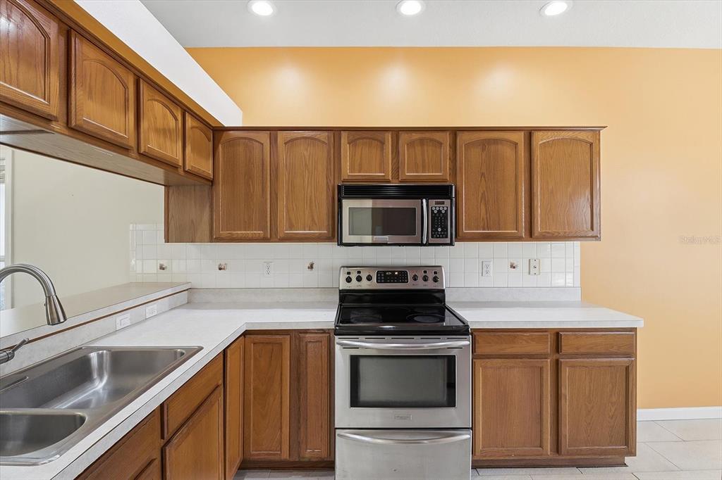 6301 West Glynborne Loop Crystal River, FL 34429 - Photo 24 of 63 a kitchen with stainless steel appliances granite countertop a sink stove and microwave
