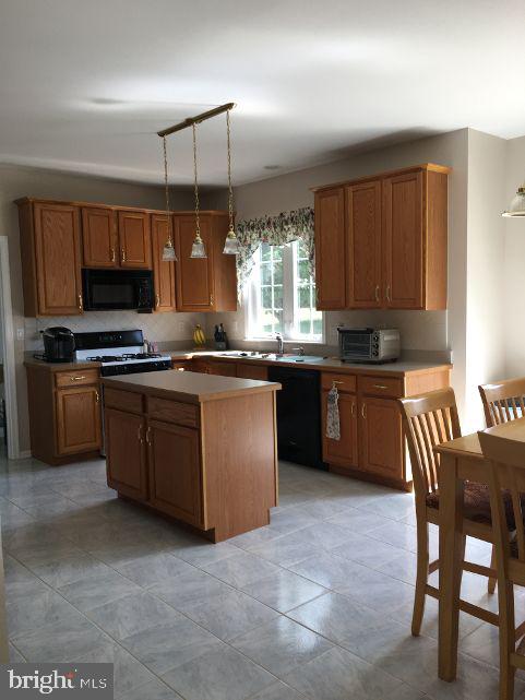 42 Hill Road Warminster, PA 18974 - Photo 17 of 44 a kitchen with kitchen island granite countertop wooden cabinets and a stove
