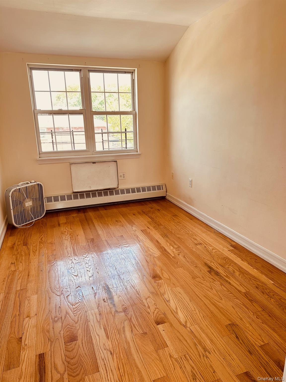 62-66 102nd Street Queens, NY 11374 - Photo 7 of 15 an empty room with wooden floor and windows