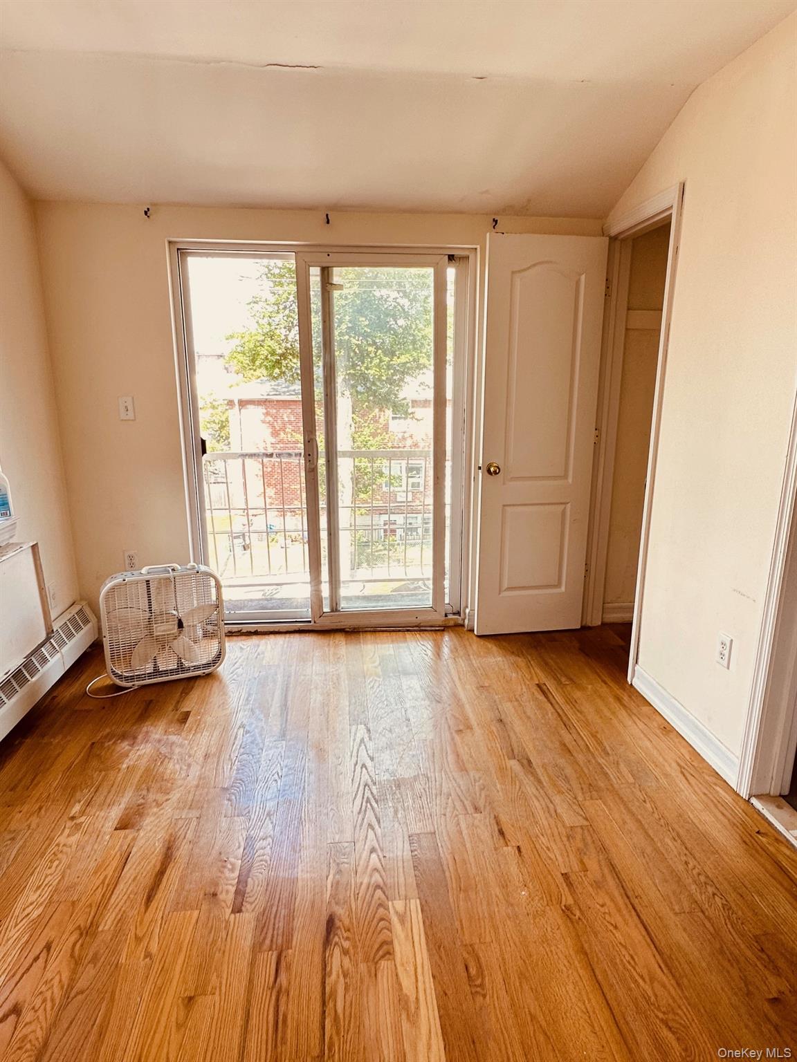62-66 102nd Street Queens, NY 11374 - Photo 8 of 15 an empty room with wooden floor and windows
