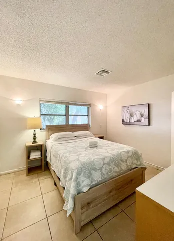 a bed sitting in a bedroom next to a lamp