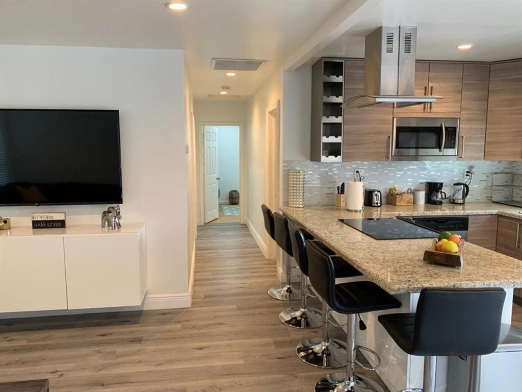 a kitchen with stainless steel appliances granite countertop a stove top oven a sink a counter space and cabinets