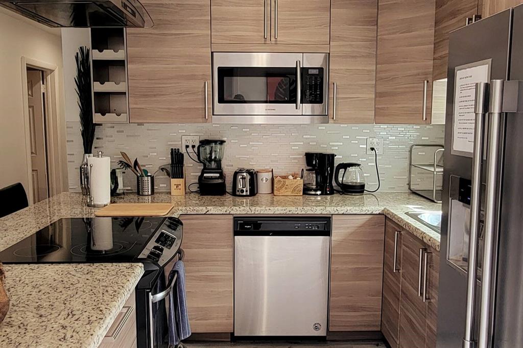 4154 Southwest 49th Street Dania Beach, FL 33314 - Photo 12 of 30 a kitchen with stainless steel appliances granite countertop a sink a stove and cabinets
