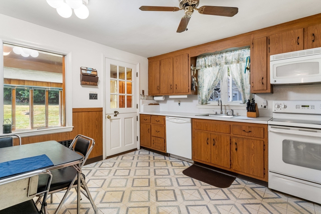 25 Centre Lane Milton, MA 02186 - Photo 8 of 32 a kitchen with a dining table chairs stainless steel appliances cabinets and a sink
