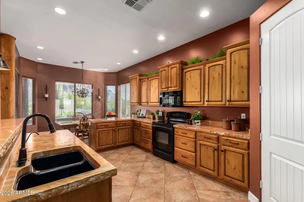 a kitchen with stainless steel appliances kitchen island granite countertop a refrigerator oven a sink dishwasher and white cabinets with wooden floor