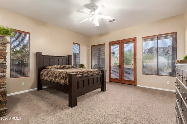 a bedroom with a bed dresser and a large window