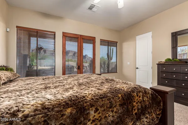 a bed sitting in a spacious bedroom next to a window and a chandelier
