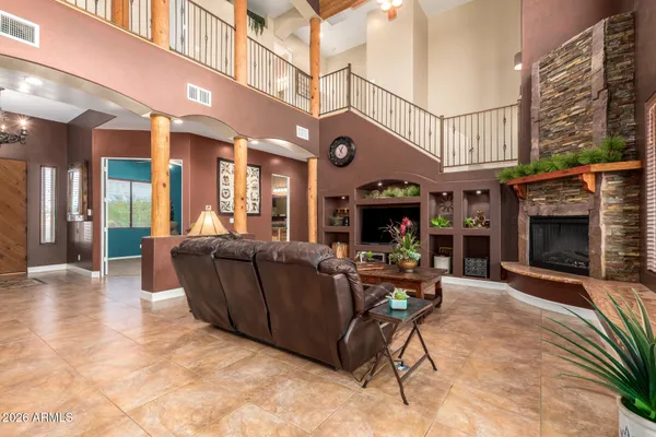 a living room with furniture a fireplace and a ceiling fan