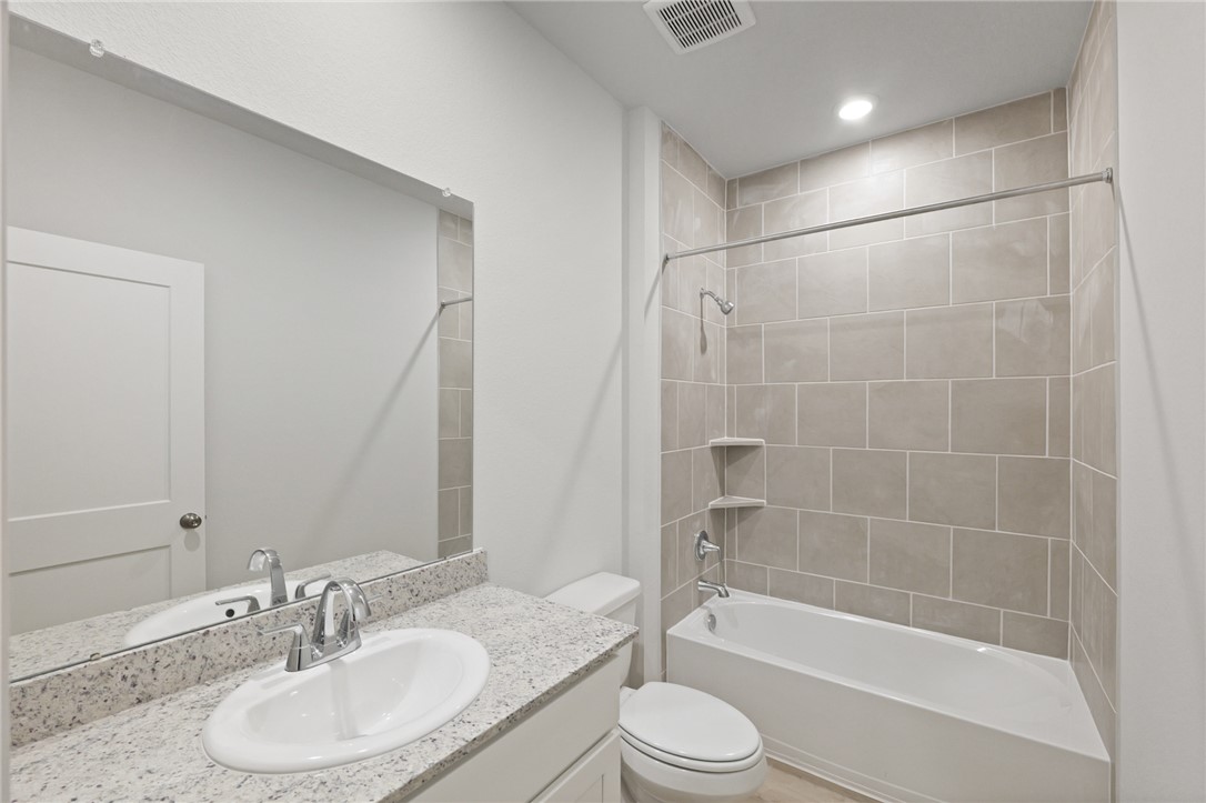 4414 Albritton Avenue Bryan, TX 77801 - Photo 6 of 30 a bathroom with a granite countertop sink toilet a mirror and shower
